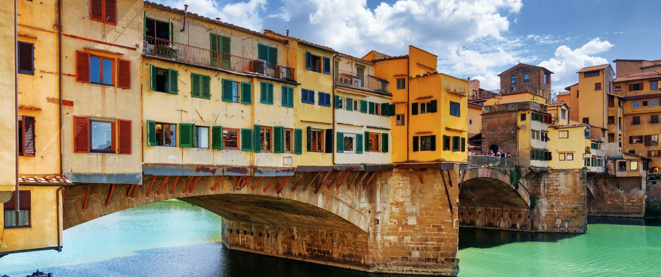 Bright yellow Ponte Vecchio, a medieval bridge in Florence, Italy.