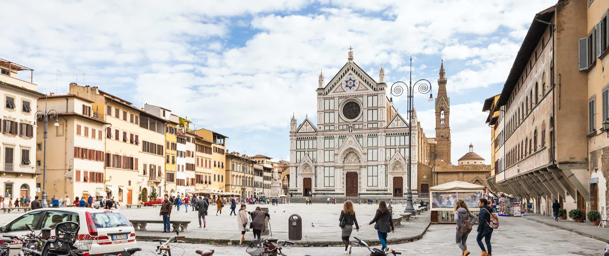 Many bicycles parked in foreground of Piazza Santa Croce in Florence, Italy