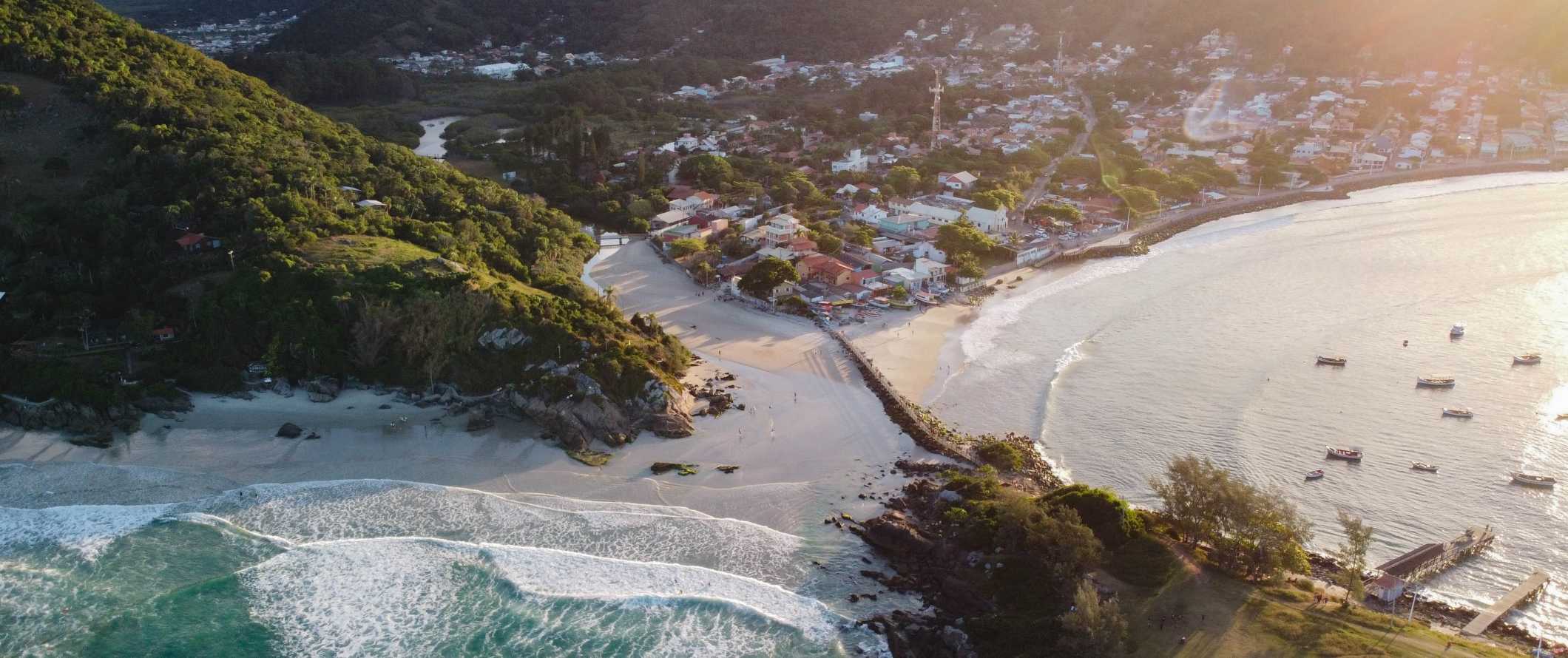 巴西Florianópolis的背景下的海滩、房屋和山脉的无人机视图