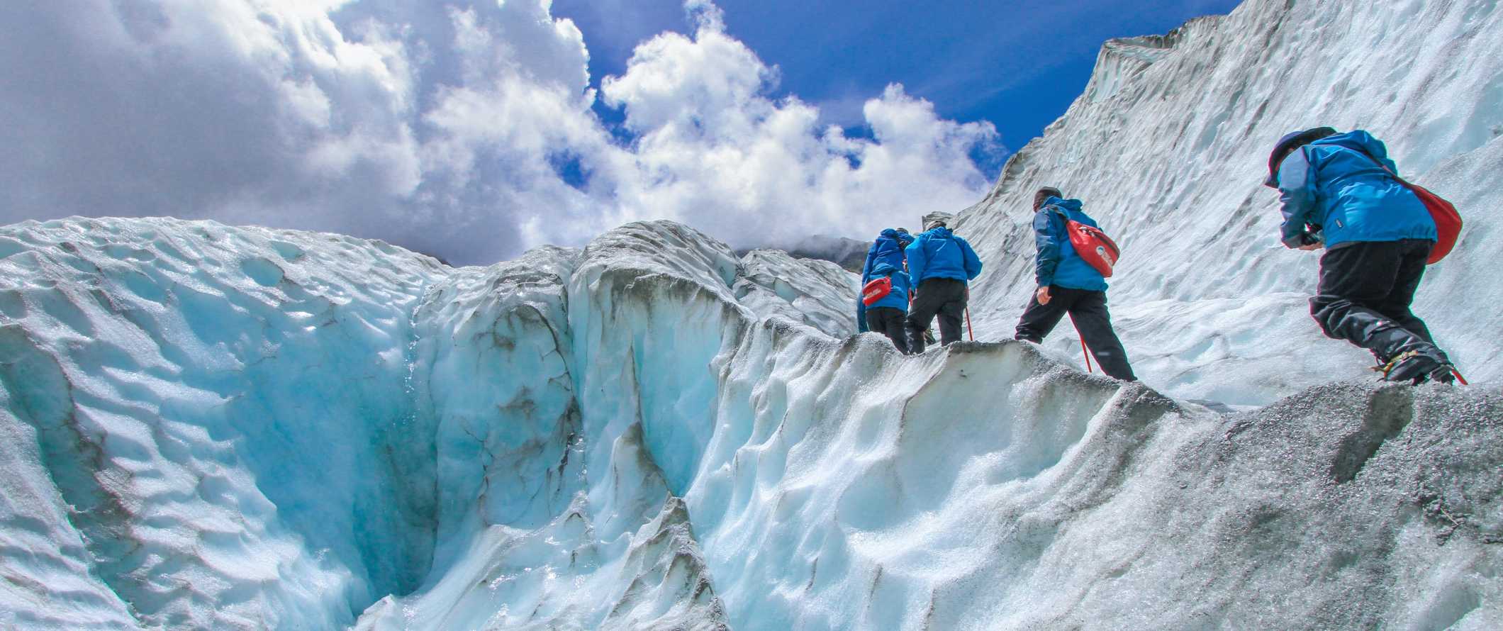 People hiking up the Franz Josef glacier in New Zealand.