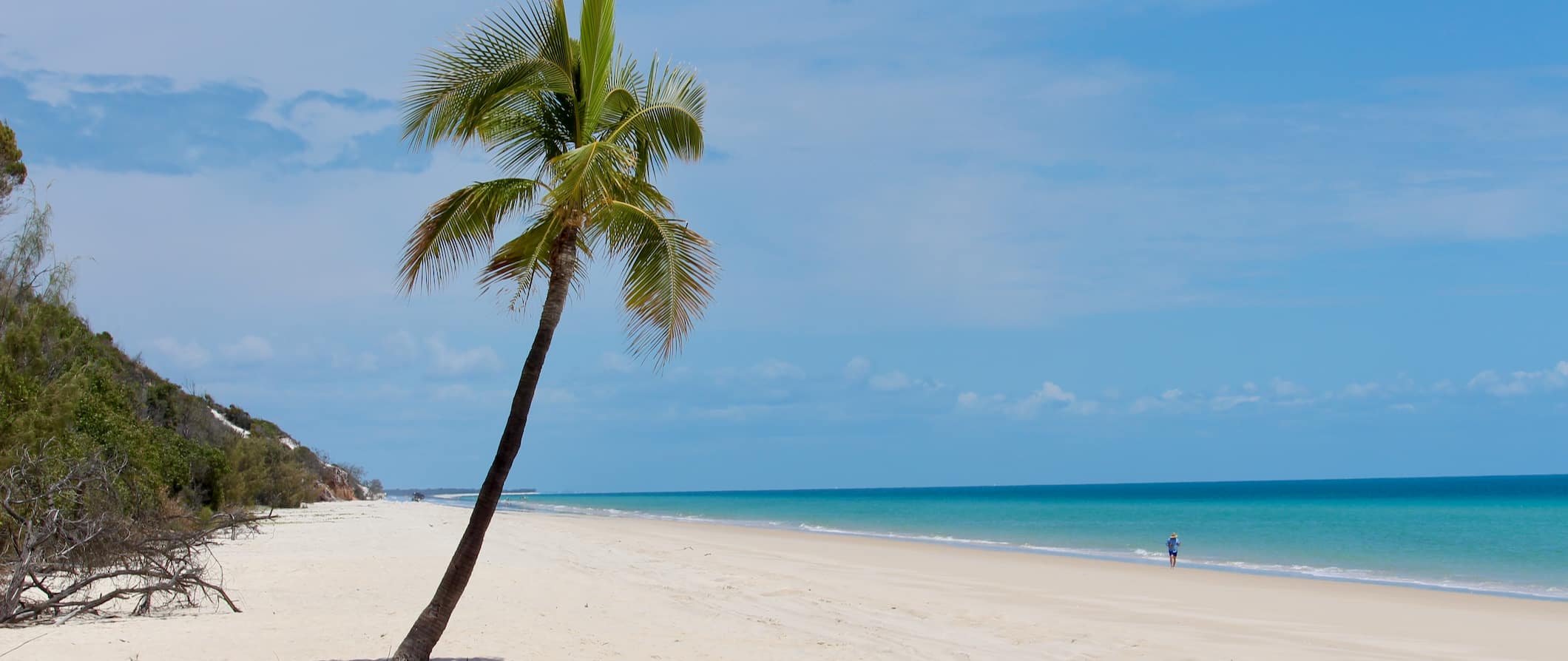 A lone tourist walking alone the wide beach of Fraser Island in Australia