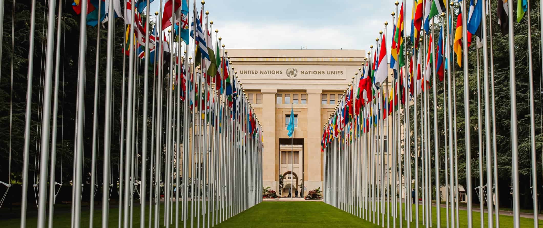 United Nations building with two rows of flags from around the world in front, in Geneva, Switzerland