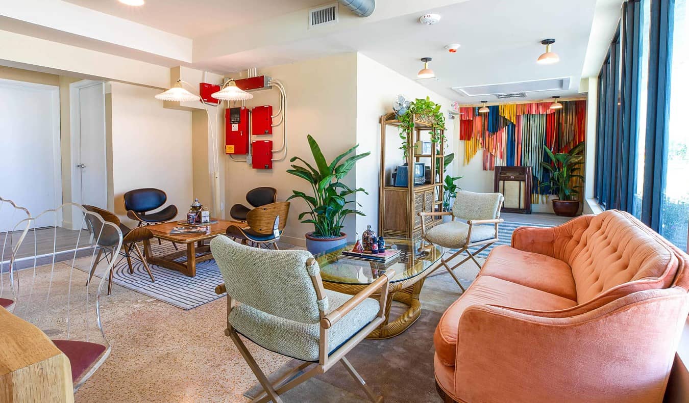 Eclectic lounge with pastel furniture at Selina Gold Dust Hostel in Miami, Florida