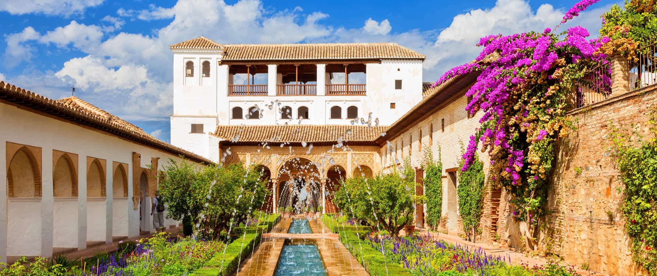 The iconic Alhambra Palace in Granada, Spain featuring a long fountain and lush greenery