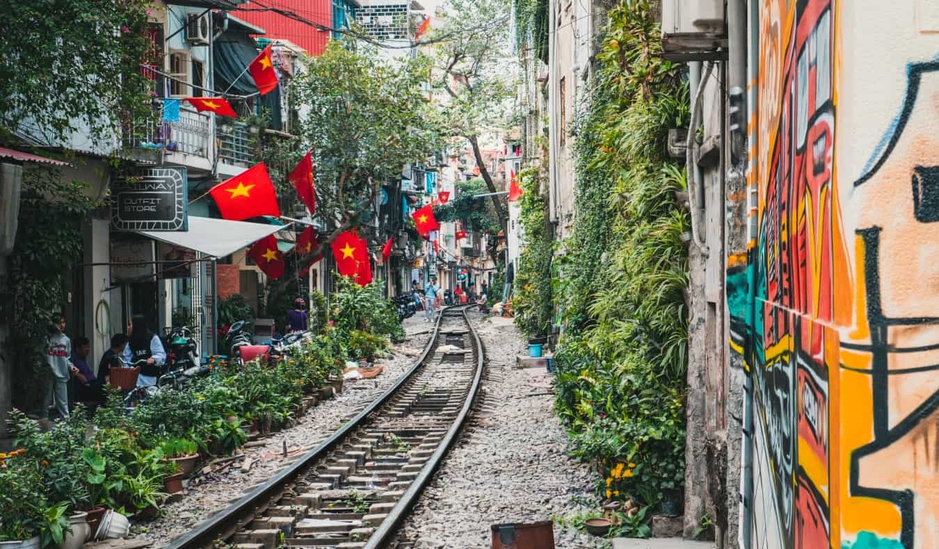 Train tracks running between close-together buildings in bustling Hanoi, Vietnam”/><br />
<a href=