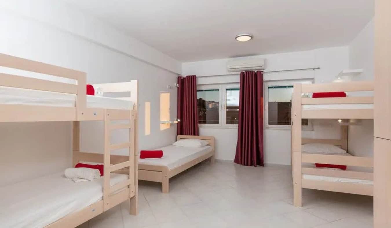 Basic dorm room with 2 bunk beds and a twin bed at Hostel Self-ruling Bird in Dubrovnik, Croatia.