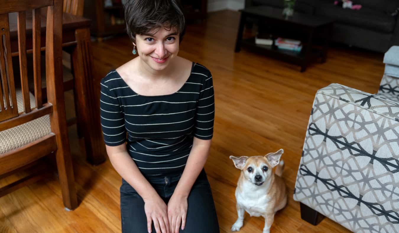 A solo female traveler posing with pets during a pet sitting job overseas