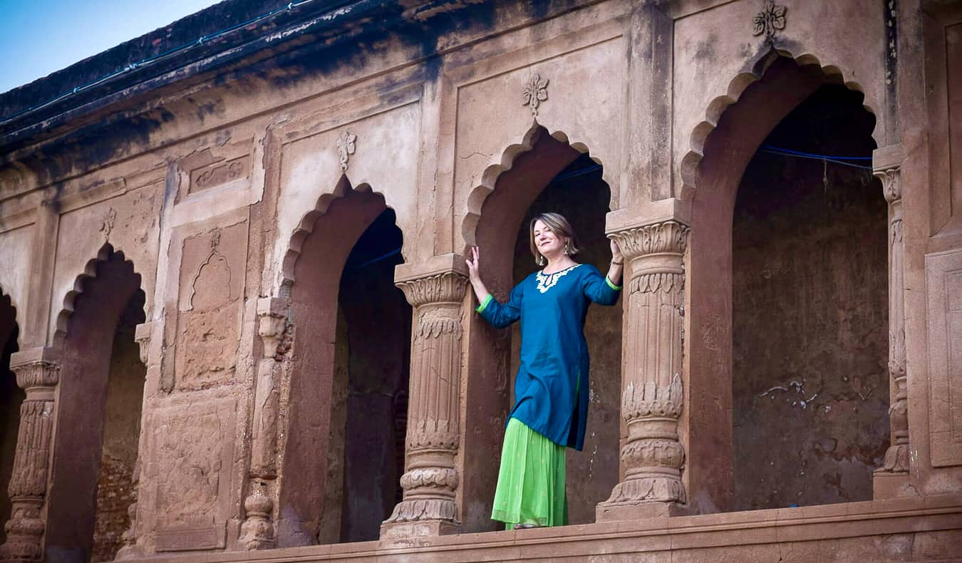 A lone traveler explores an ancient historical building in India.