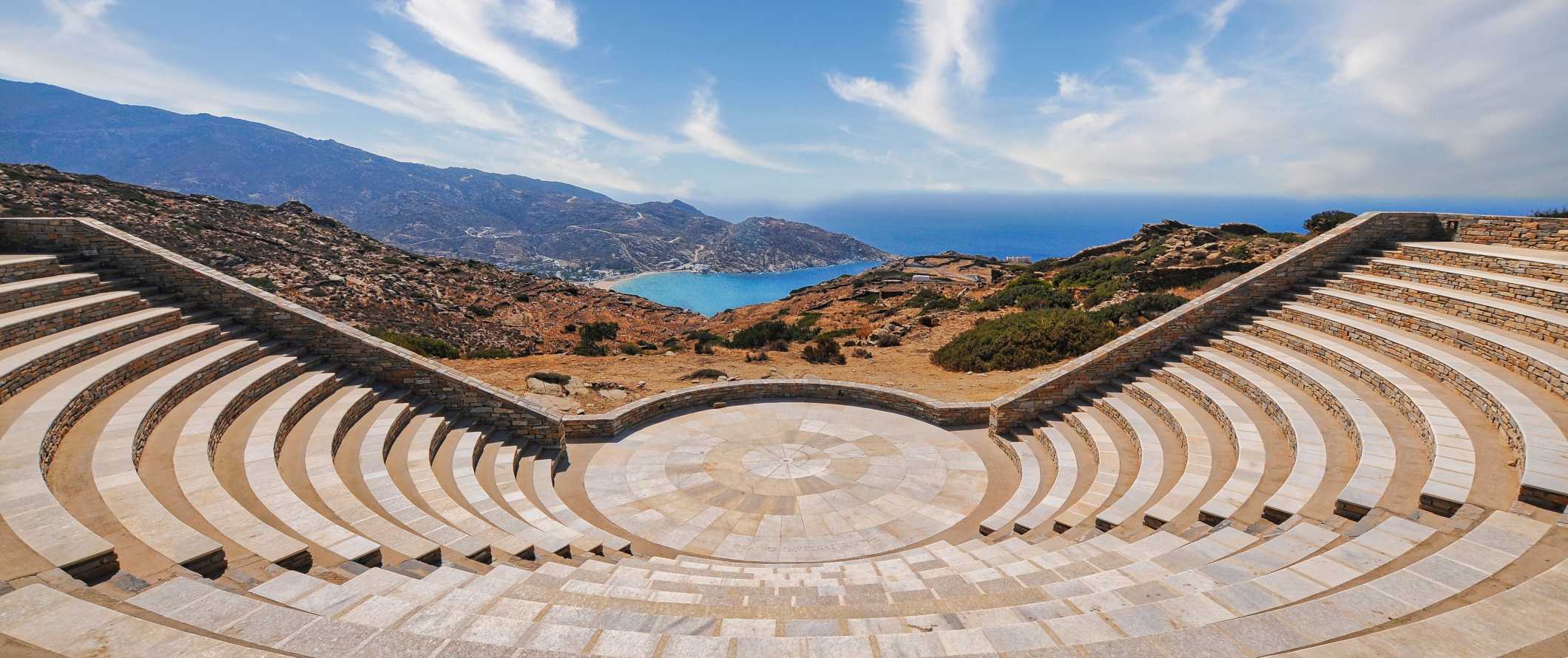 Panoramic view of modern open-air amphitheatre overlooking hilltops and the Mediterranean Sea in Ios, Greece