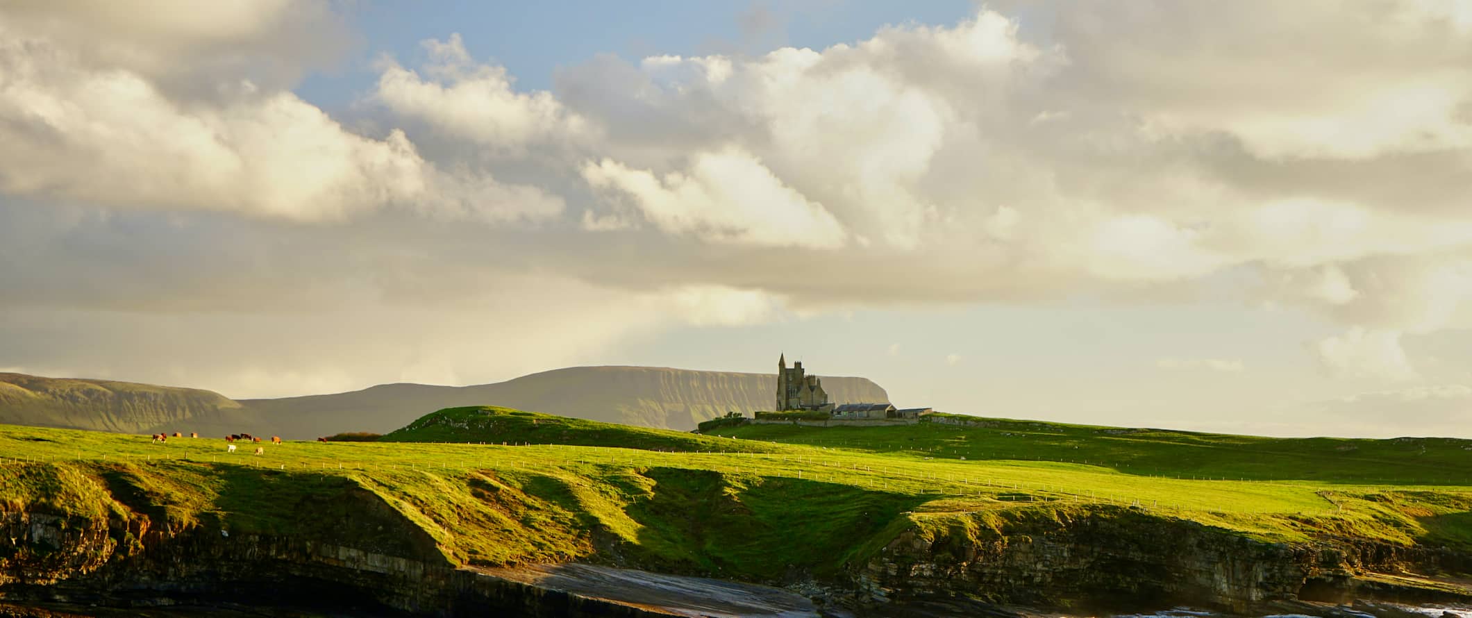 a castle countryside of Ireland surrounded by rolling, green fields