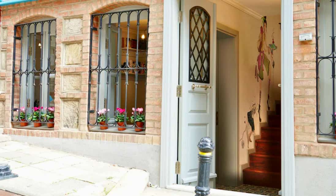 The front exterior of Tilas House hostel in Istanbul, Turkey, featuring an unshut door on a quiet street