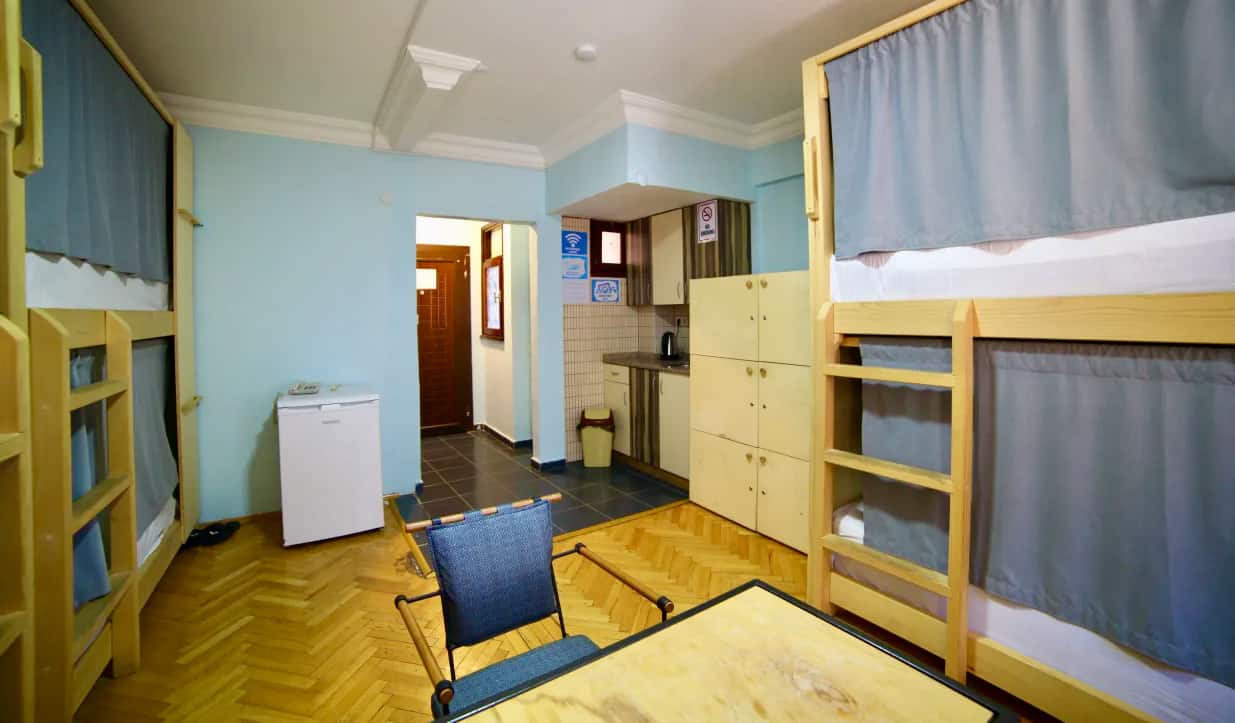 The interior of Yolo Hostel in Istanbul, Turkey, with wooden bunk beds and curtains in a small dorm room