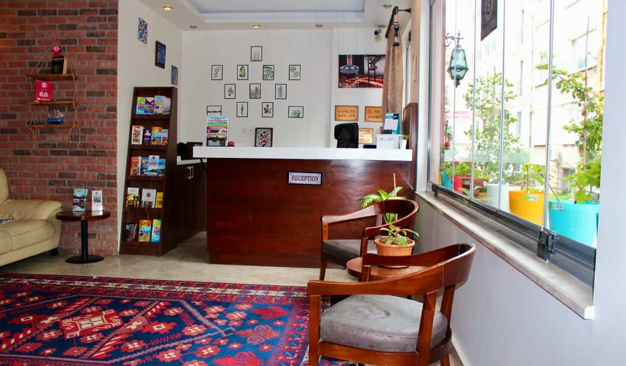 The front desk of Stanpoli Hostel, with a colorful carpet near the entrance in Istanbul, Turkey