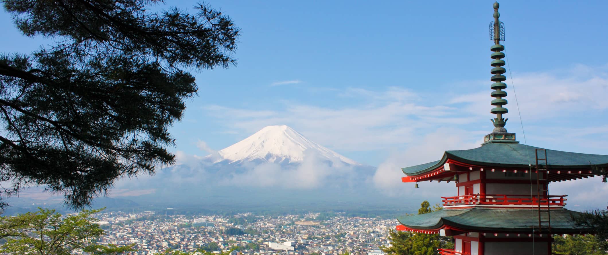 Mount Fuji in the distance on a sunny day with a pagoda in the foreground in Japan