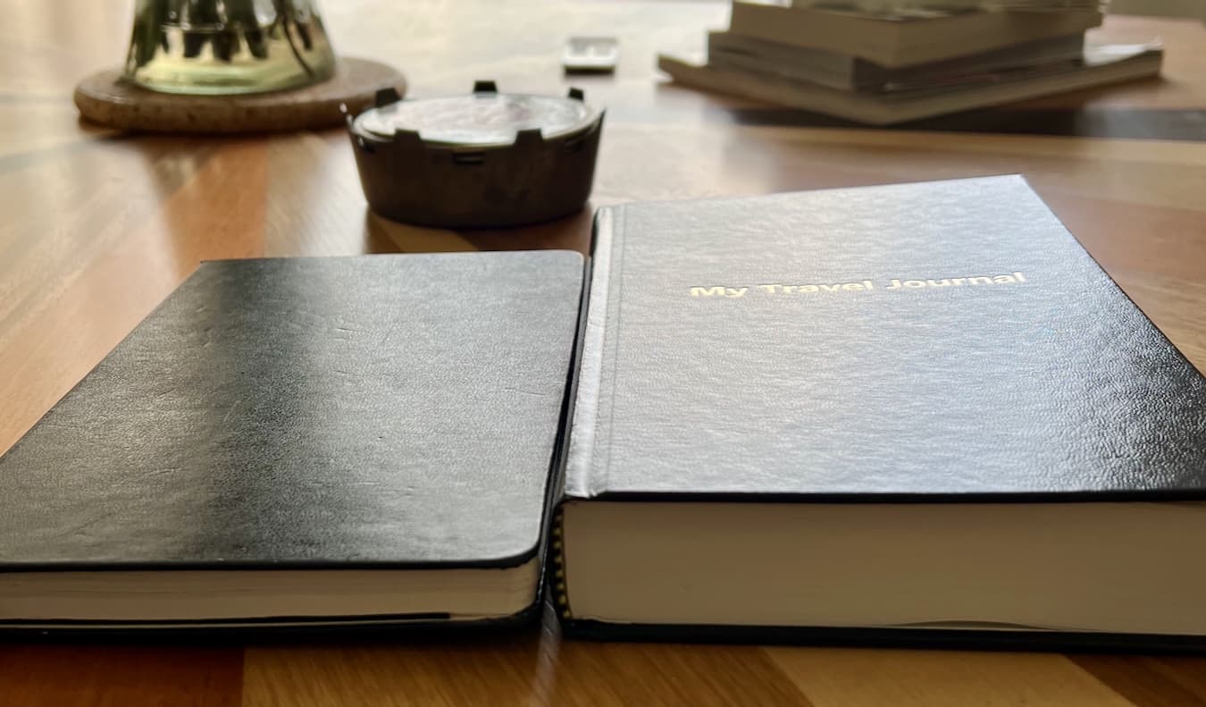 The Remember Your Travels journal compared to a Moleskine journal, side by side
