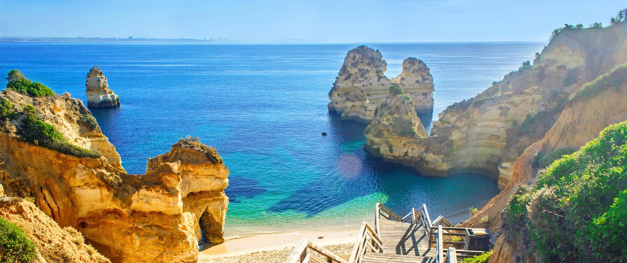 A wooden set of stairs going down to a gorgeous beach along the coast of Portugal near Lagos