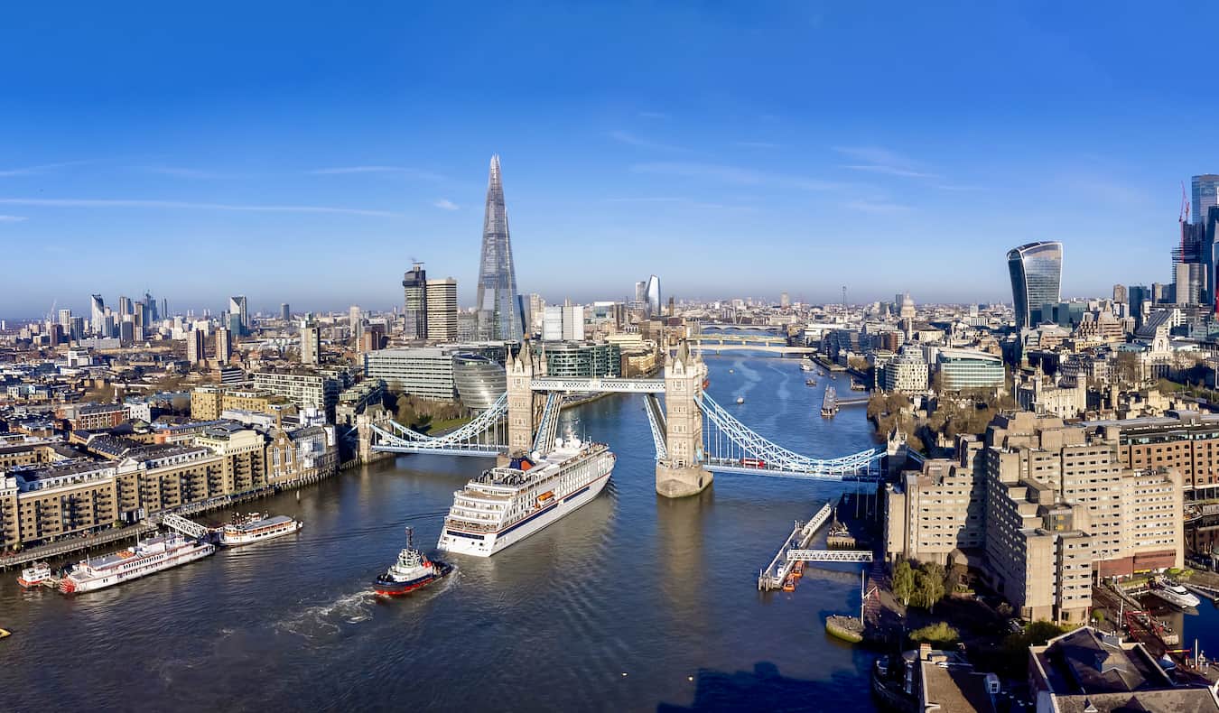 The iconic London skyline over the Thames with boats cruising up the river