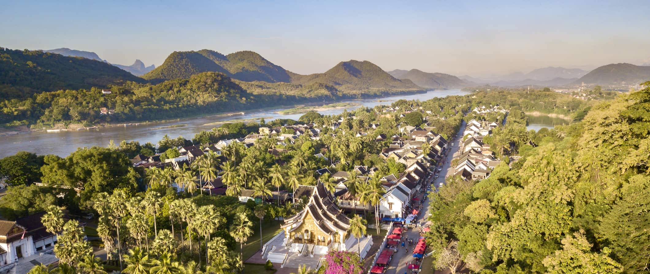 An aerial view of lush Luang Prabang in Laos, with mountains in the background