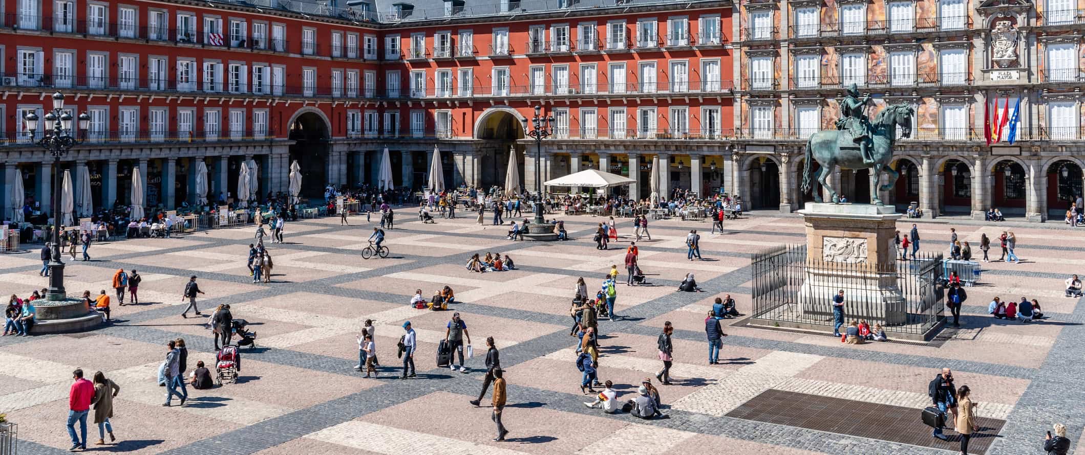 People relaxing and strolling around a huge plaza in Madrid, Spain