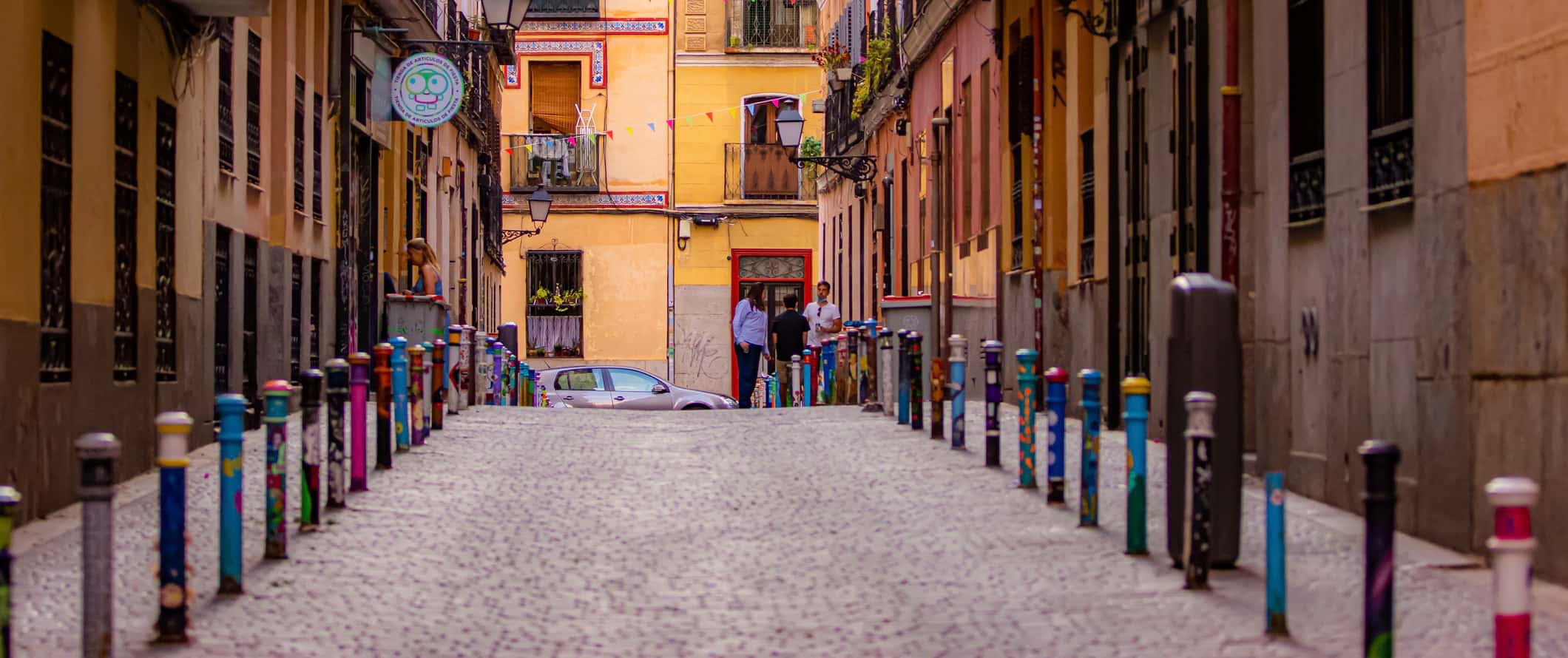 A narrow cobblestone street enveloped by old buildings in Madrid, Spain