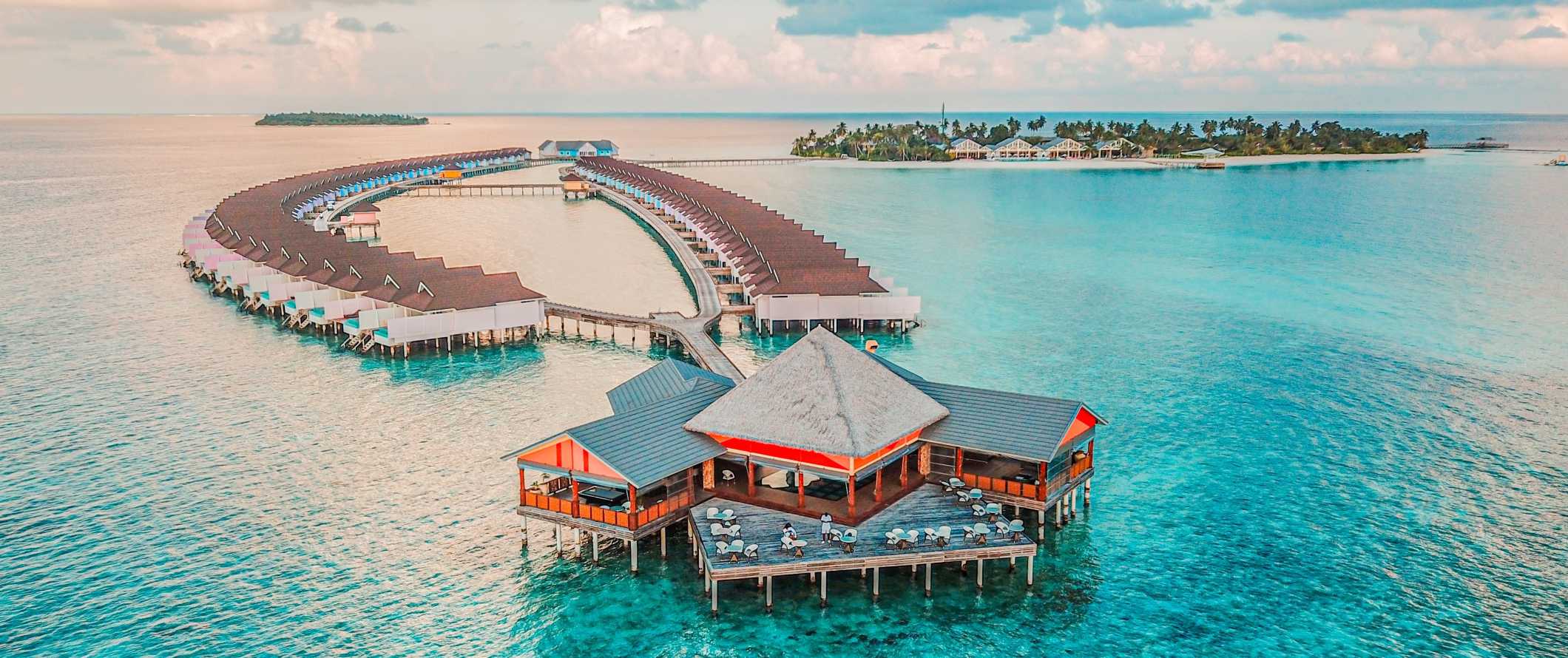 Connected thatched over-water bungalows at a resort in the Maldives