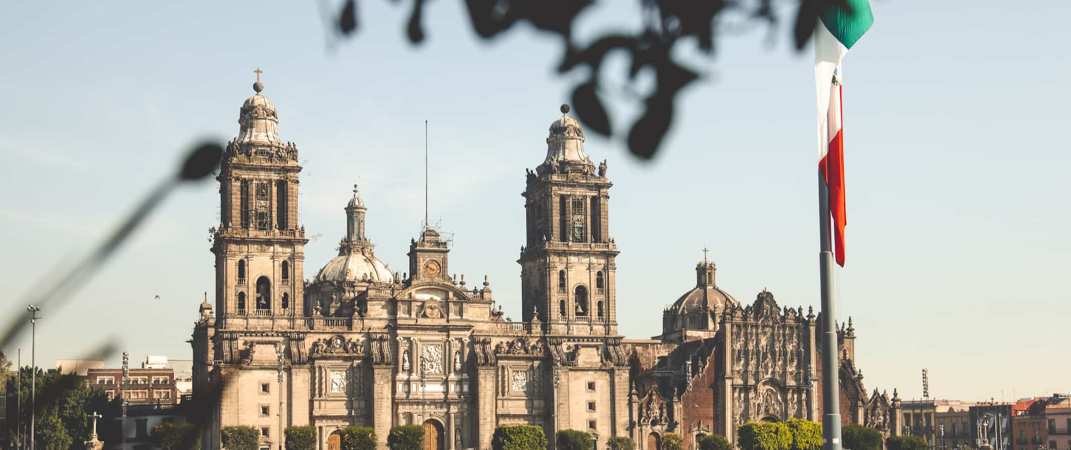 A drooping Mexican flag near one of Mexico City's iconic historic buildings