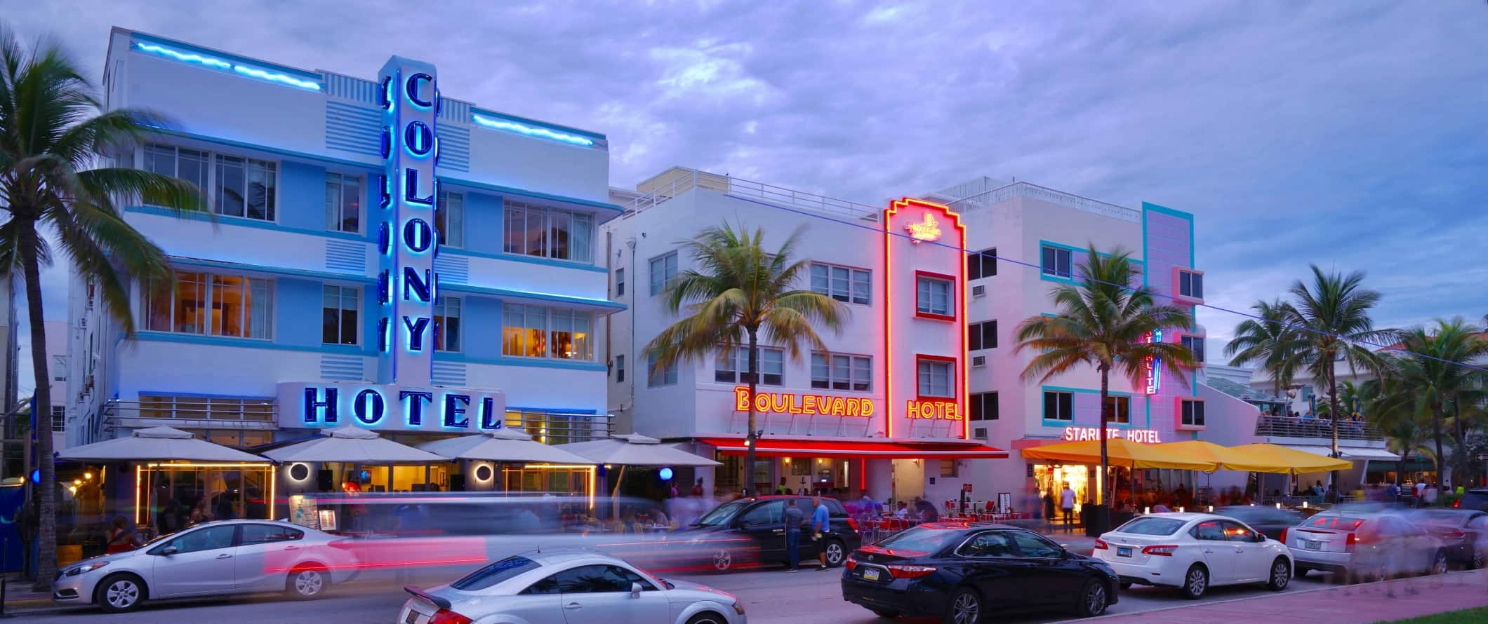 Art deco buildings lit up in neon lights at sunset in South Beach, Miami, Florida