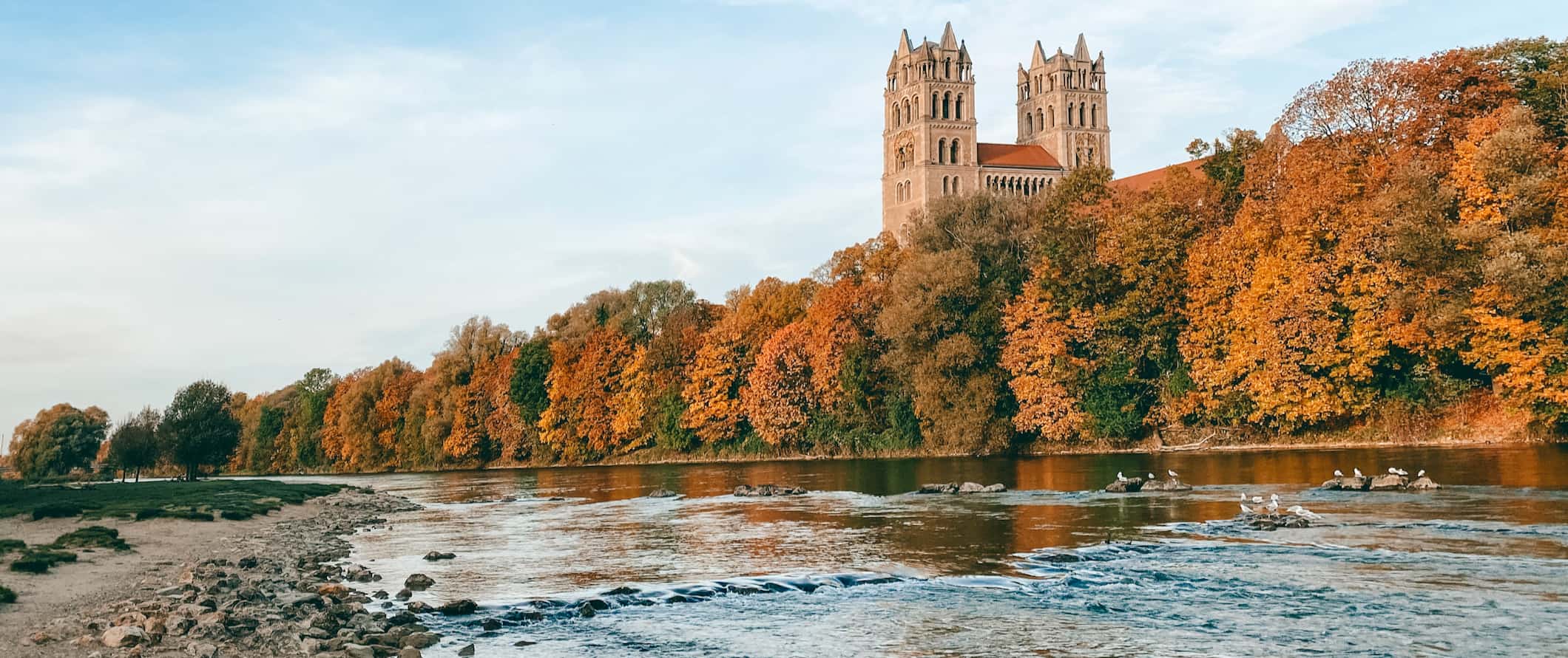 Munich, Germany as seen from the river surrounded by trees on a quiet day