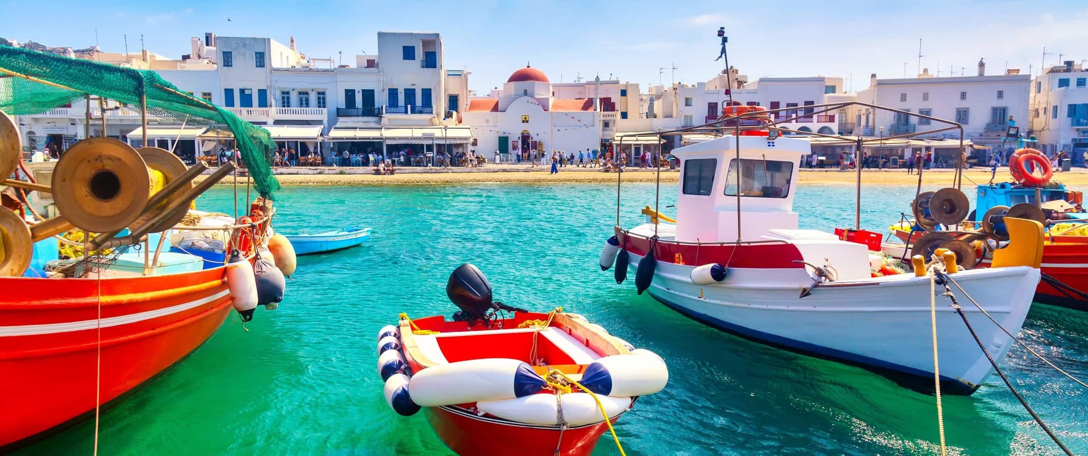 Brightly colored boats in the old port of Chora on the island of Mykonos in Greece.