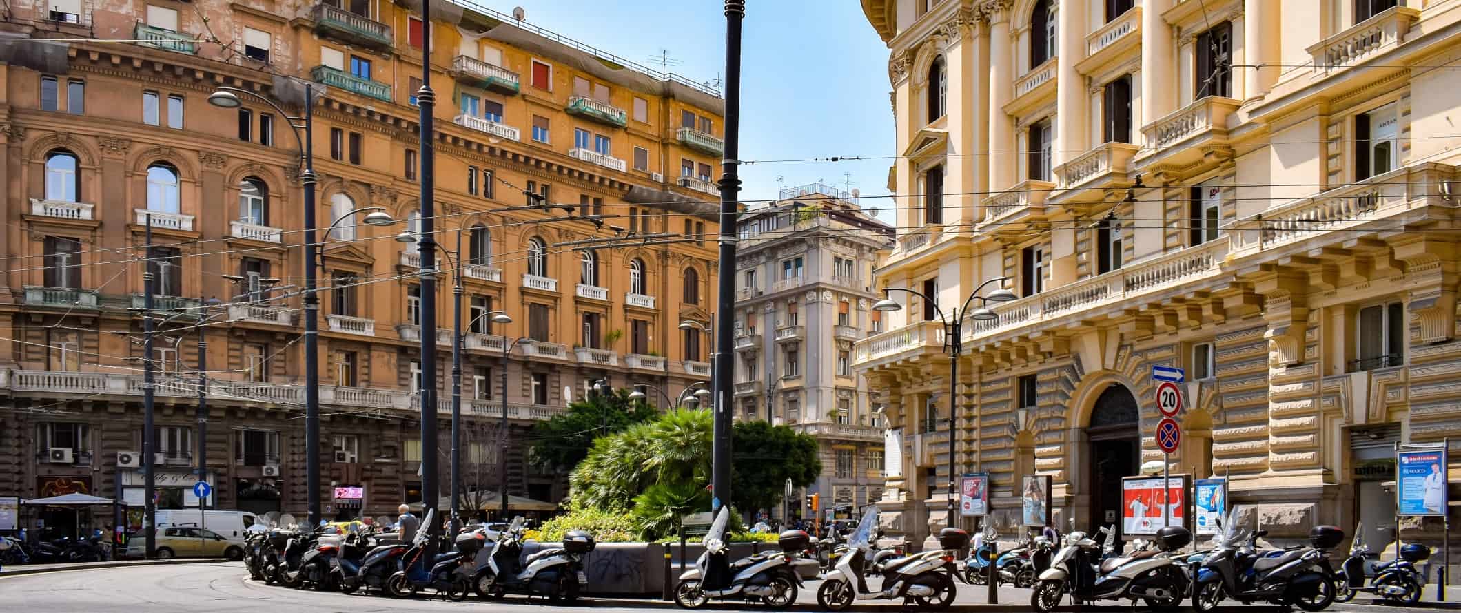 Mopeds lined up along a colorful street in Naples, Italy.