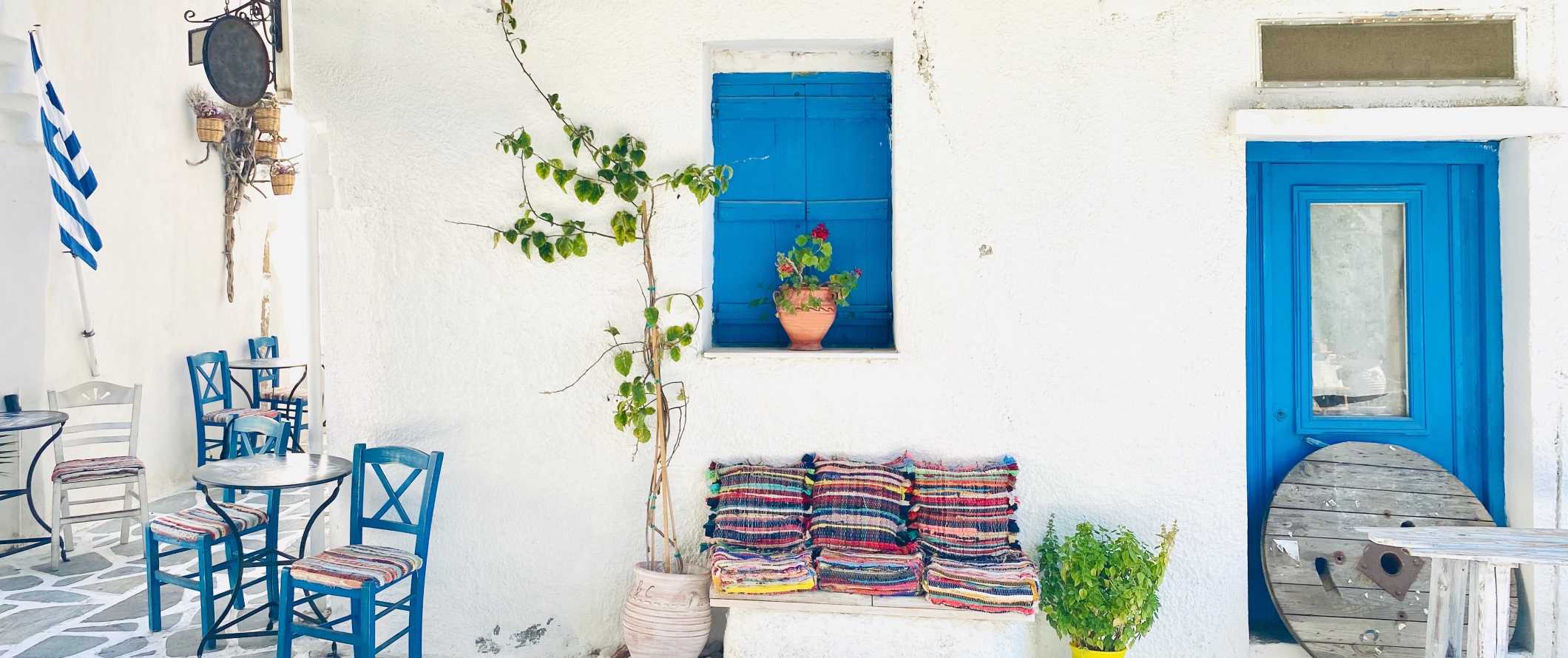 white-washed building with blue door and window frames in Naxos, Greece.