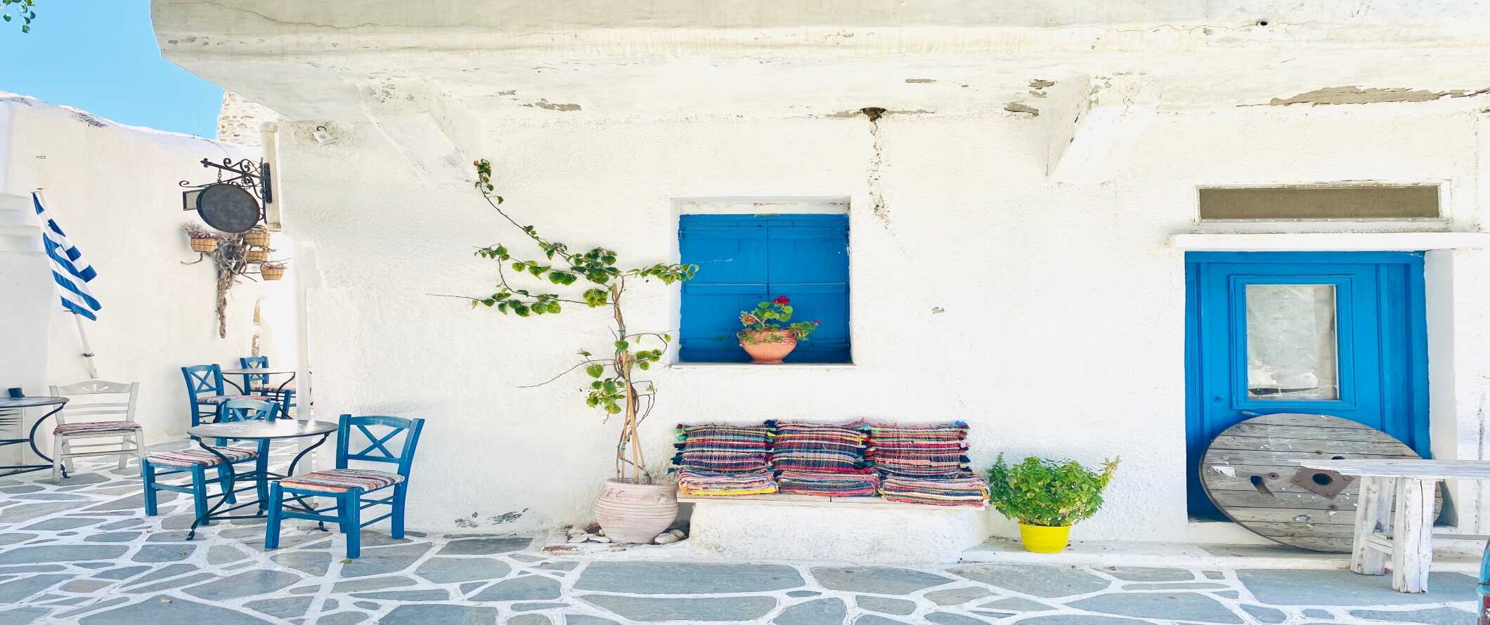 white-washed building with blue door and window frames in Naxos, Greece.