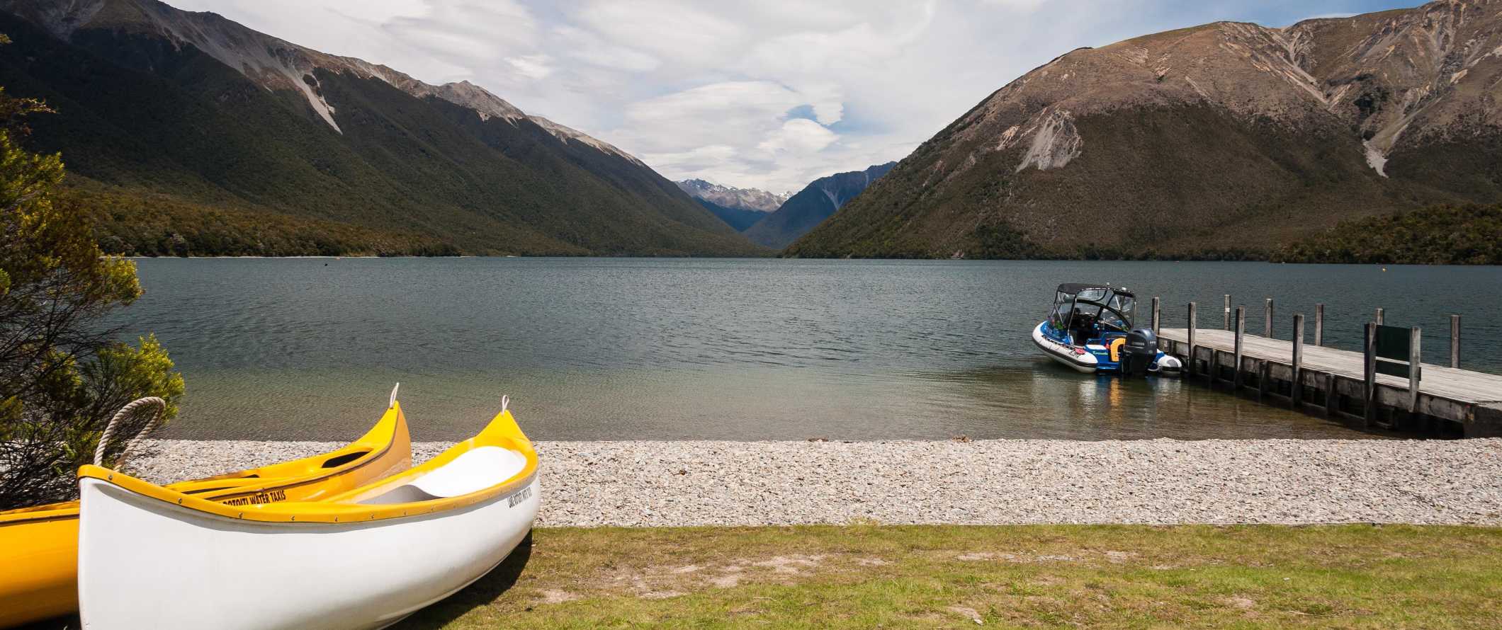 Canoe along the water with mountains in the background near the town of Nelson, New Zealand.