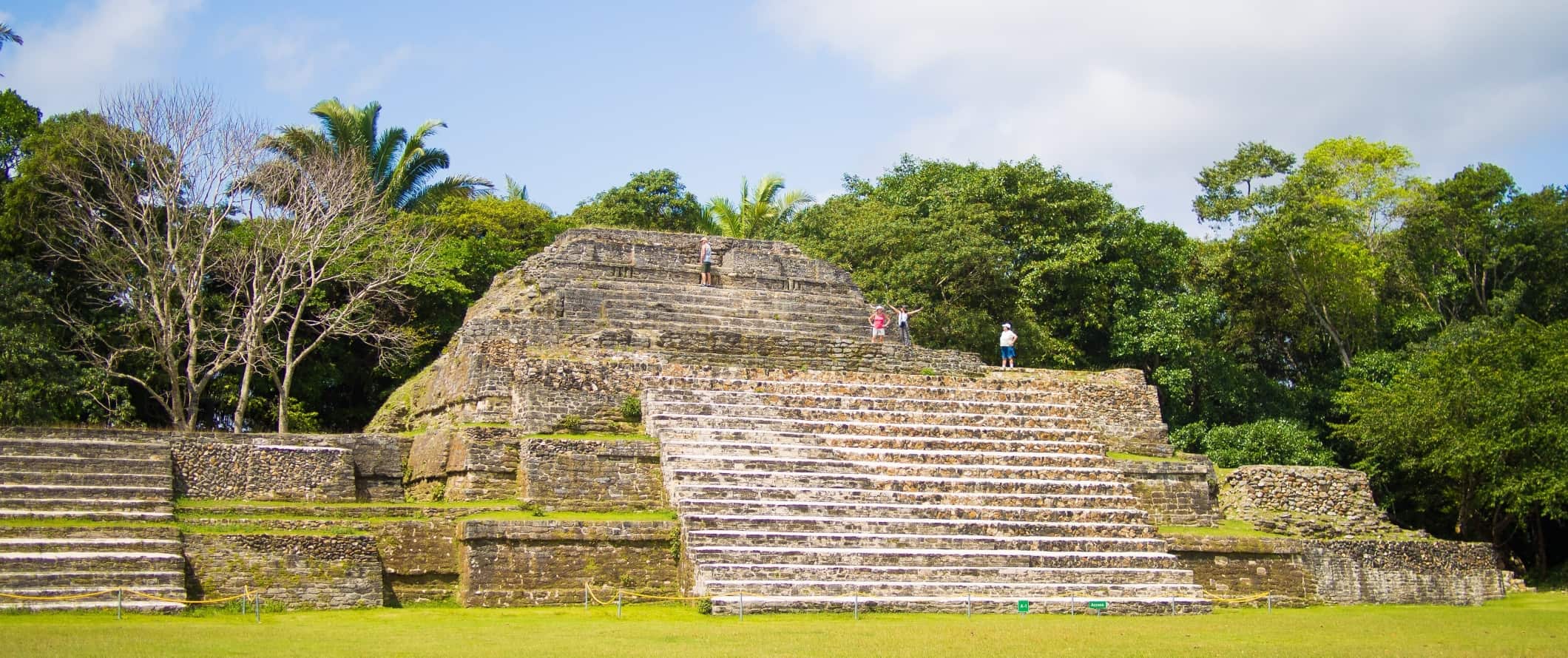 people walking around on top of the tiered pyramids of Mayan ruins, Altun Ha, in Belize