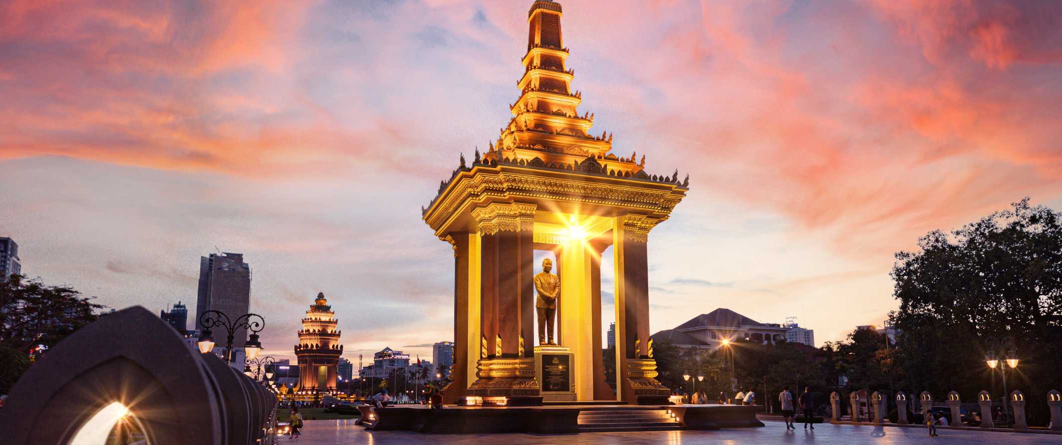 The golden statue of late King Father Norodom Sihanouk, a major landmark in Phnom Penh, Cambodia at sunset
