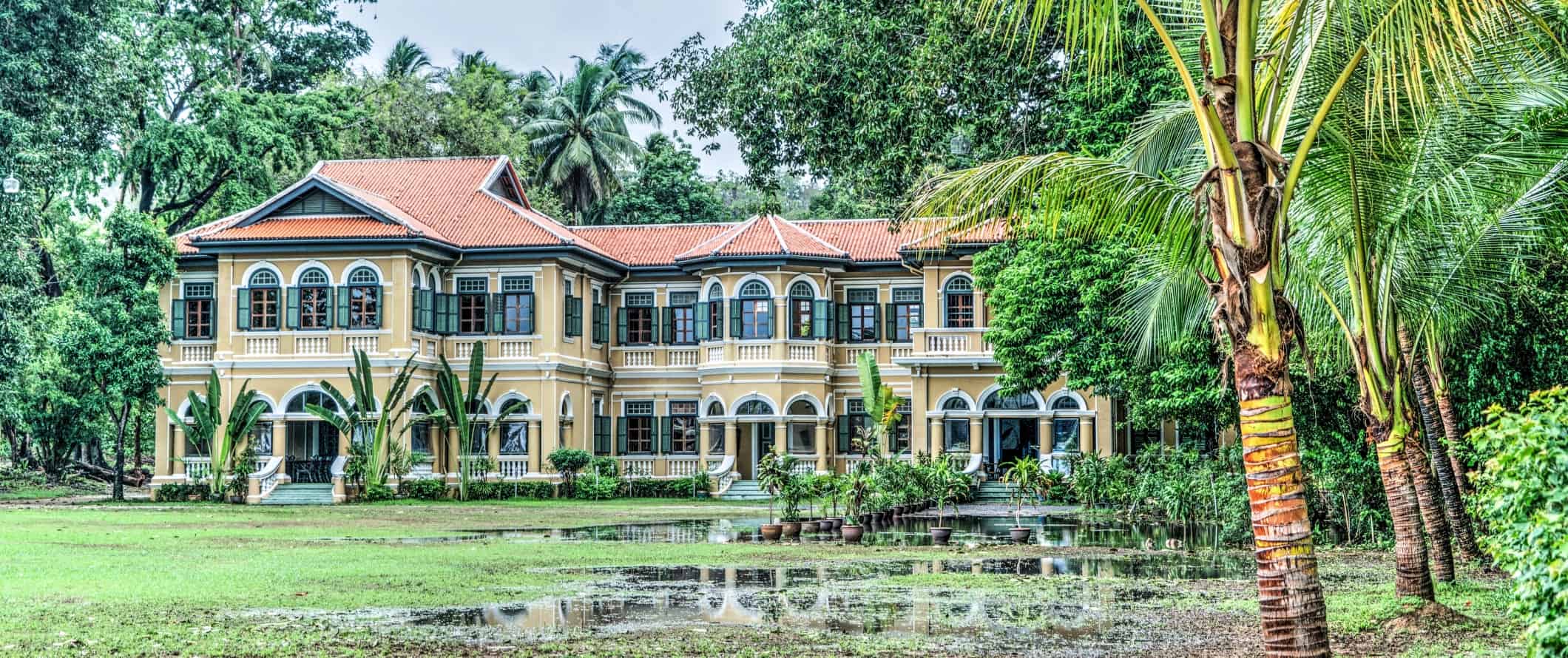 Stately yellow building with a terracotta roof in the jungle of Phuket, Thailand