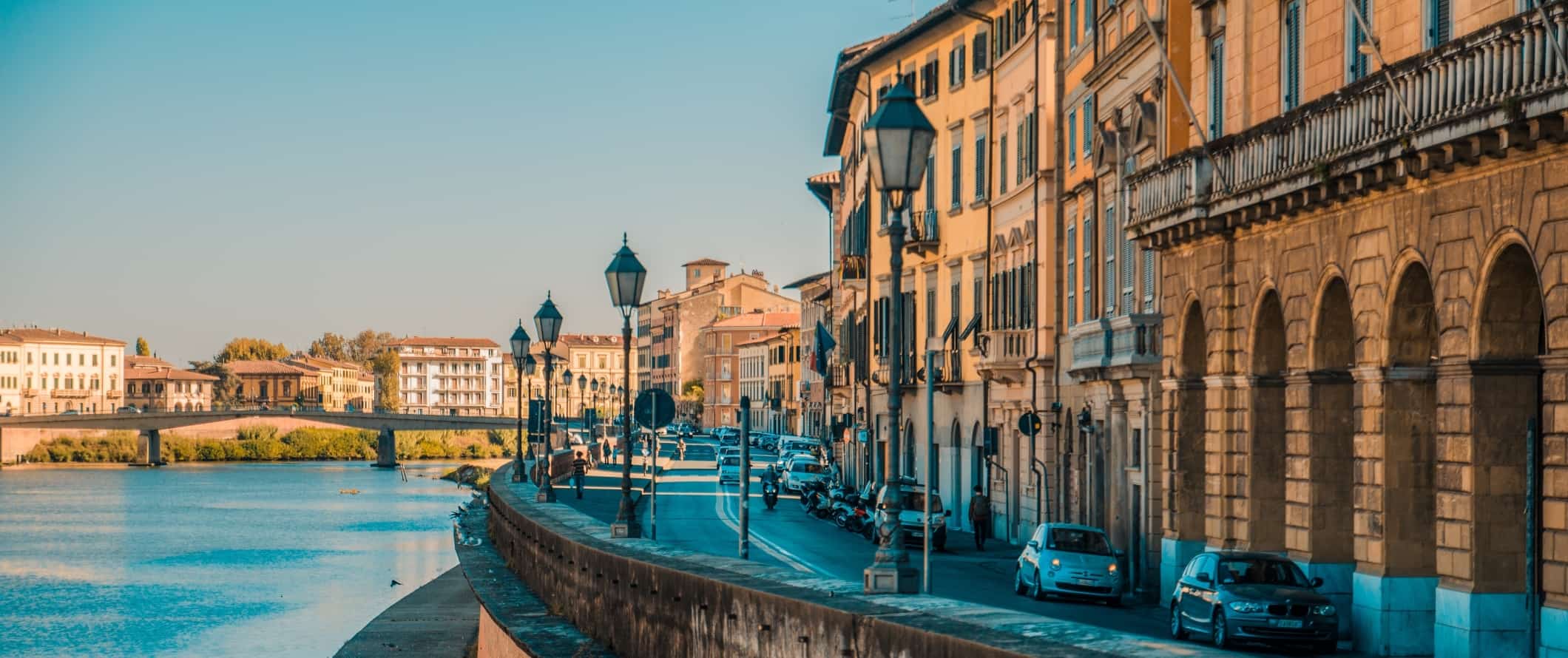 Buildings and winding road along the riverfront of Pisa, Italy.