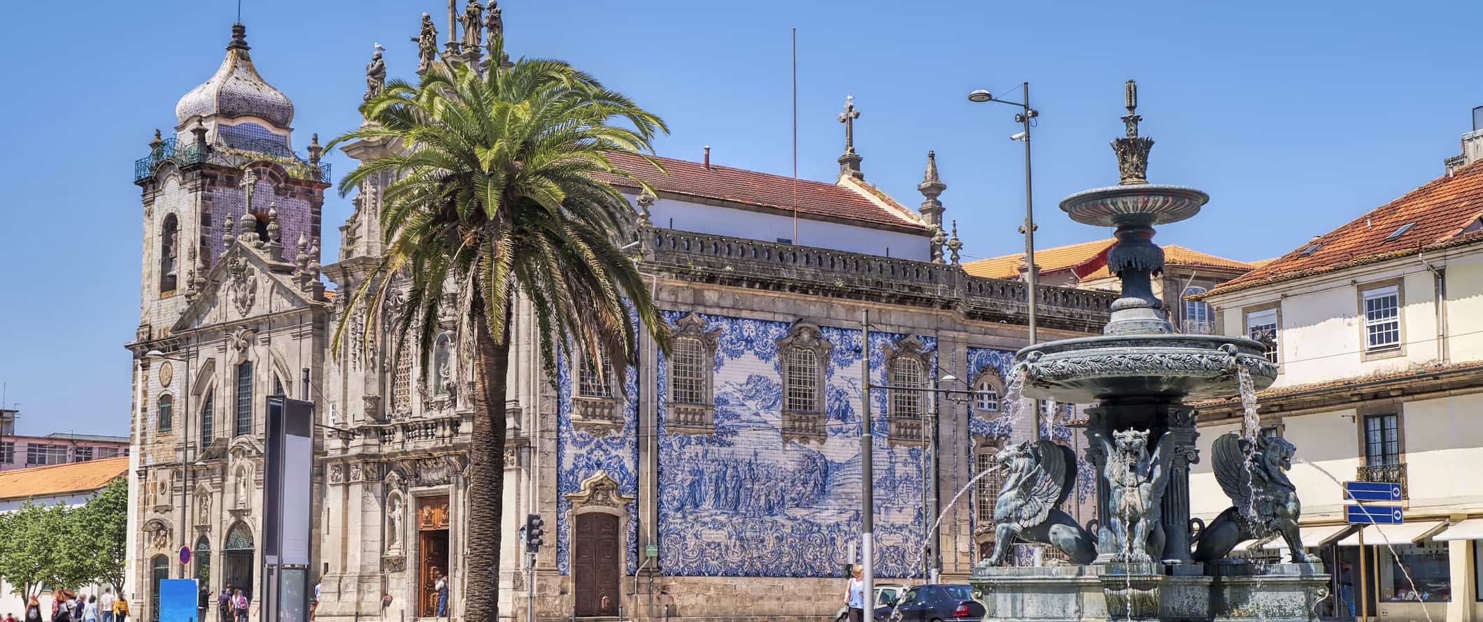 An iconic church in sunny Porto, Portugal with a fountain in the foreground
