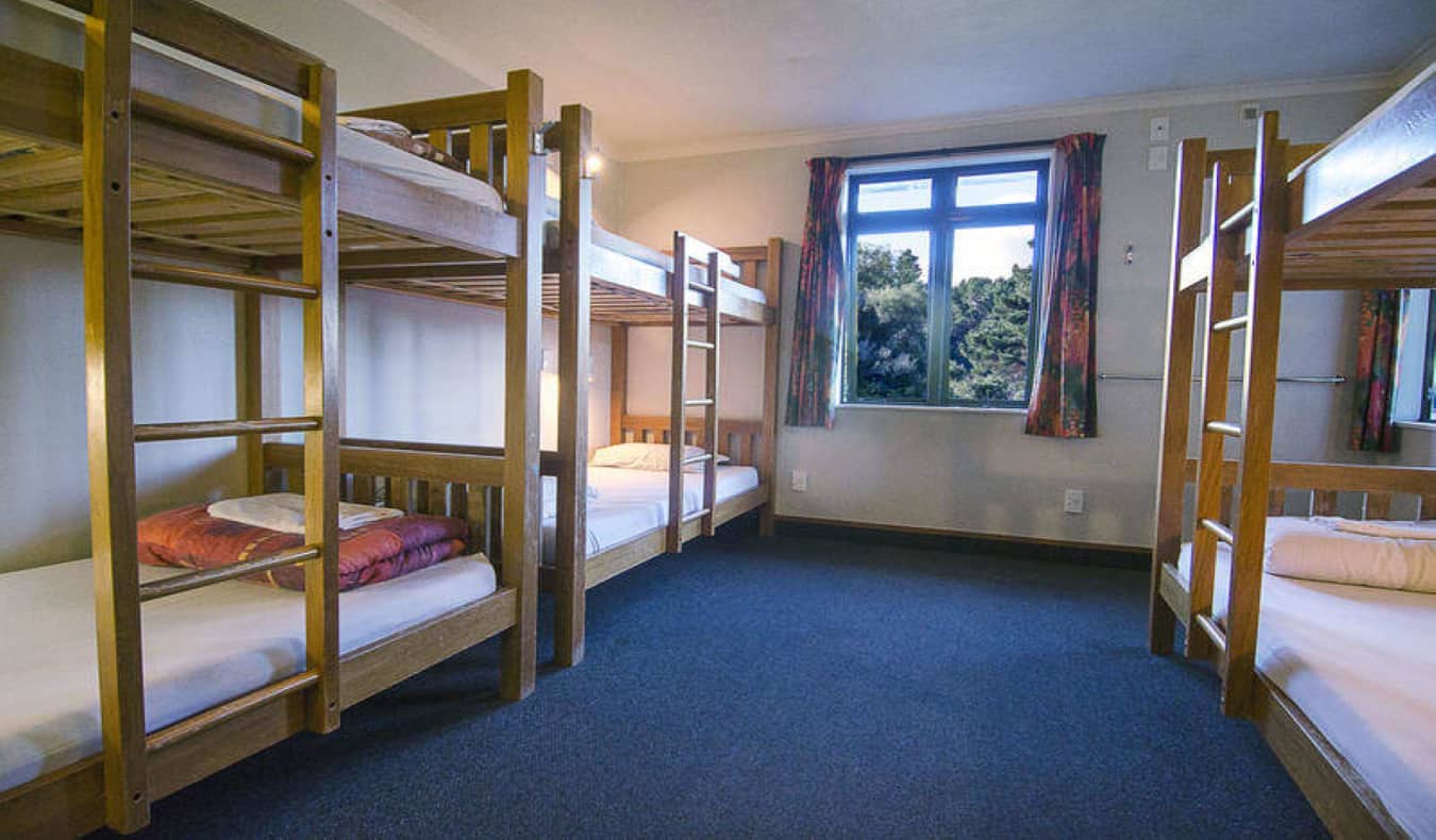 Dorm room with wooden bunk beds at Rainbow Lodge
