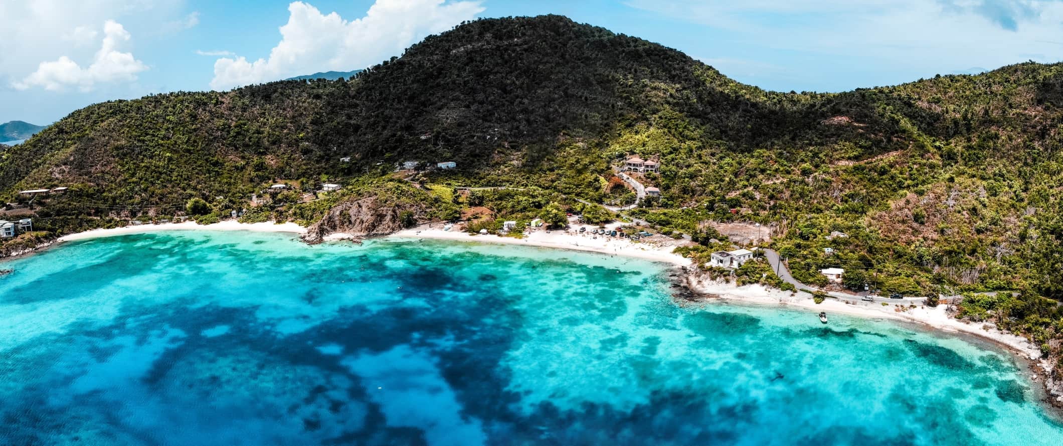 Panoramic view of the crystal clear turquoise water, white sand beaches, and rolling green hills of Saint John, USVI