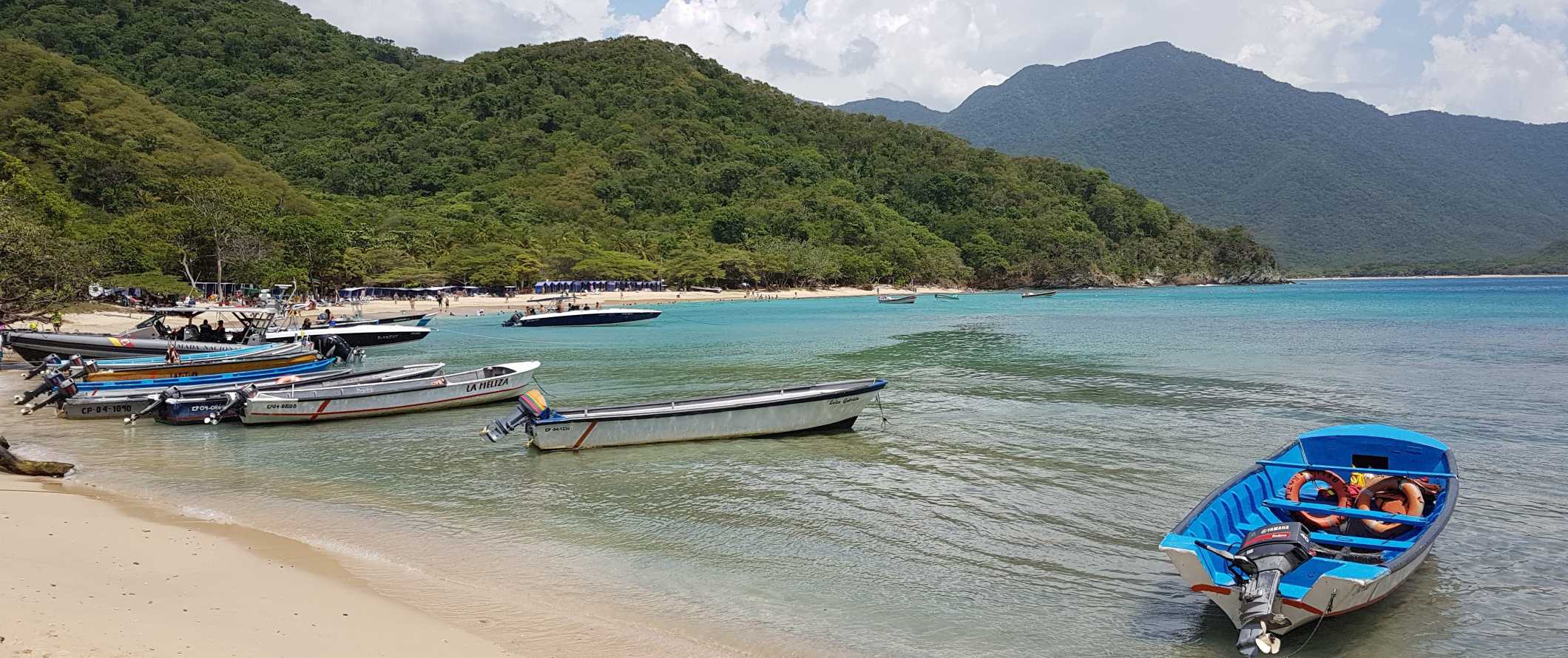 Small boats pulled up on a beach in Parque Tayrona, a national park in Colombia