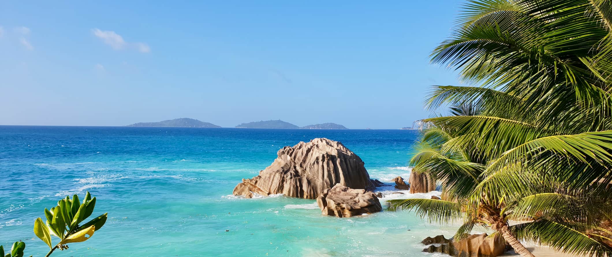 A tropical beach in Seychelles with white sand and a bright blue sky above