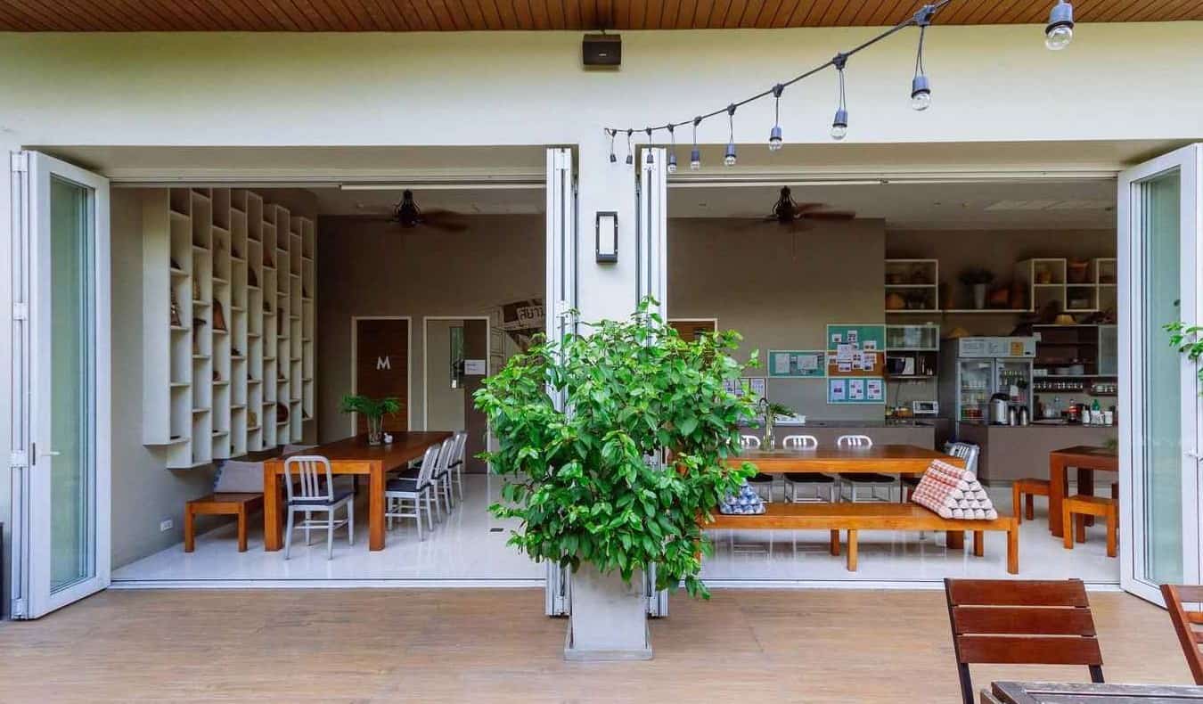 Outdoor patio and doors opening into indoor dining area at Siamaze Hostel Bangkok