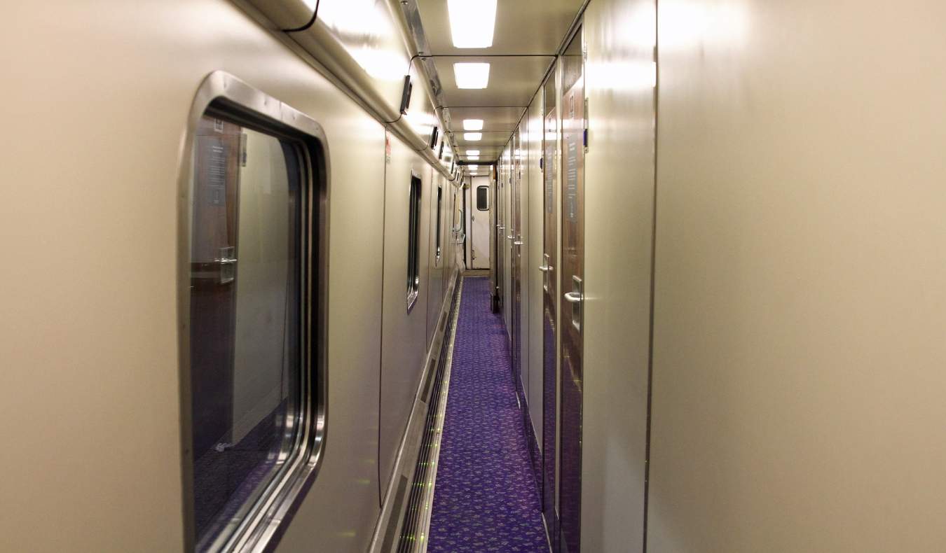 long train corridor lined with sleeper compartment doors