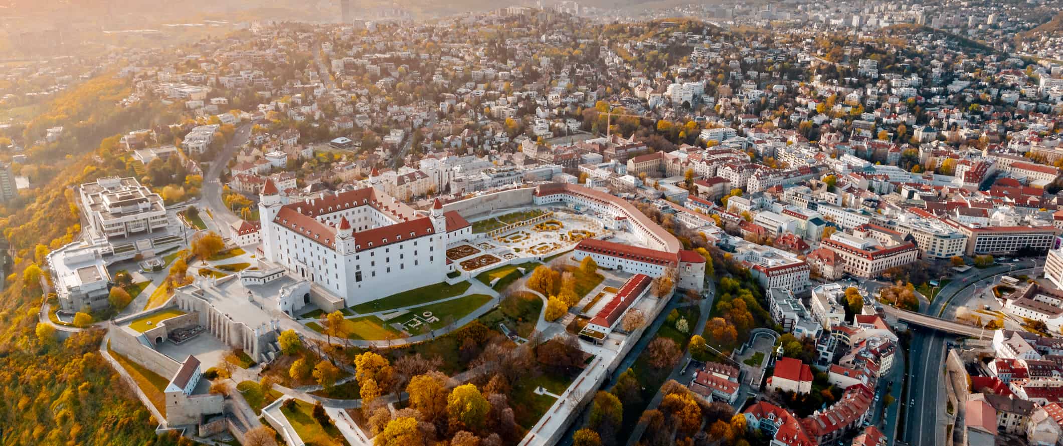 An aerial view of Bratislava, the capital of Slovakia, featuring historic buildings and plenty of greenery