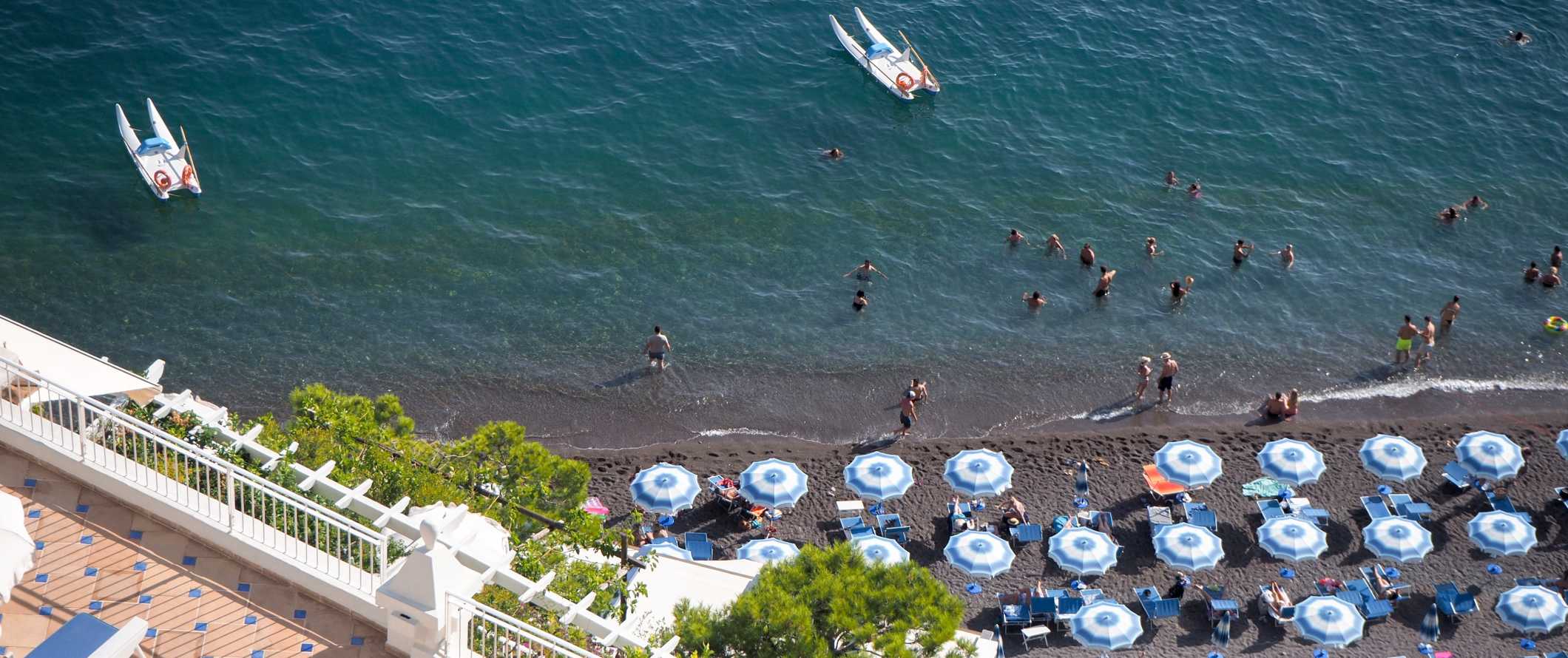Aerial views of umbrellas and beach chairs on the beach in Sorrento, Italy.