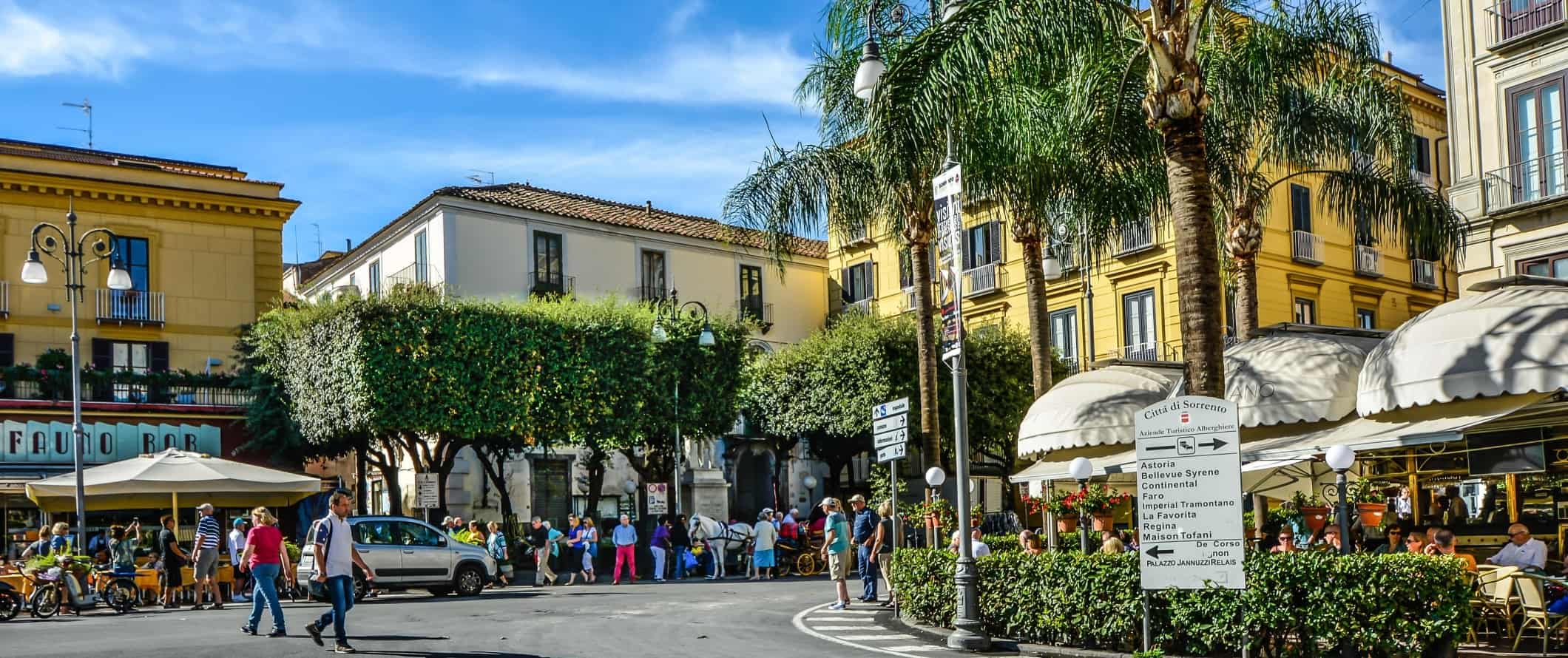 Street scene of a lively plaza with people walking around in Sorrento, Italy.