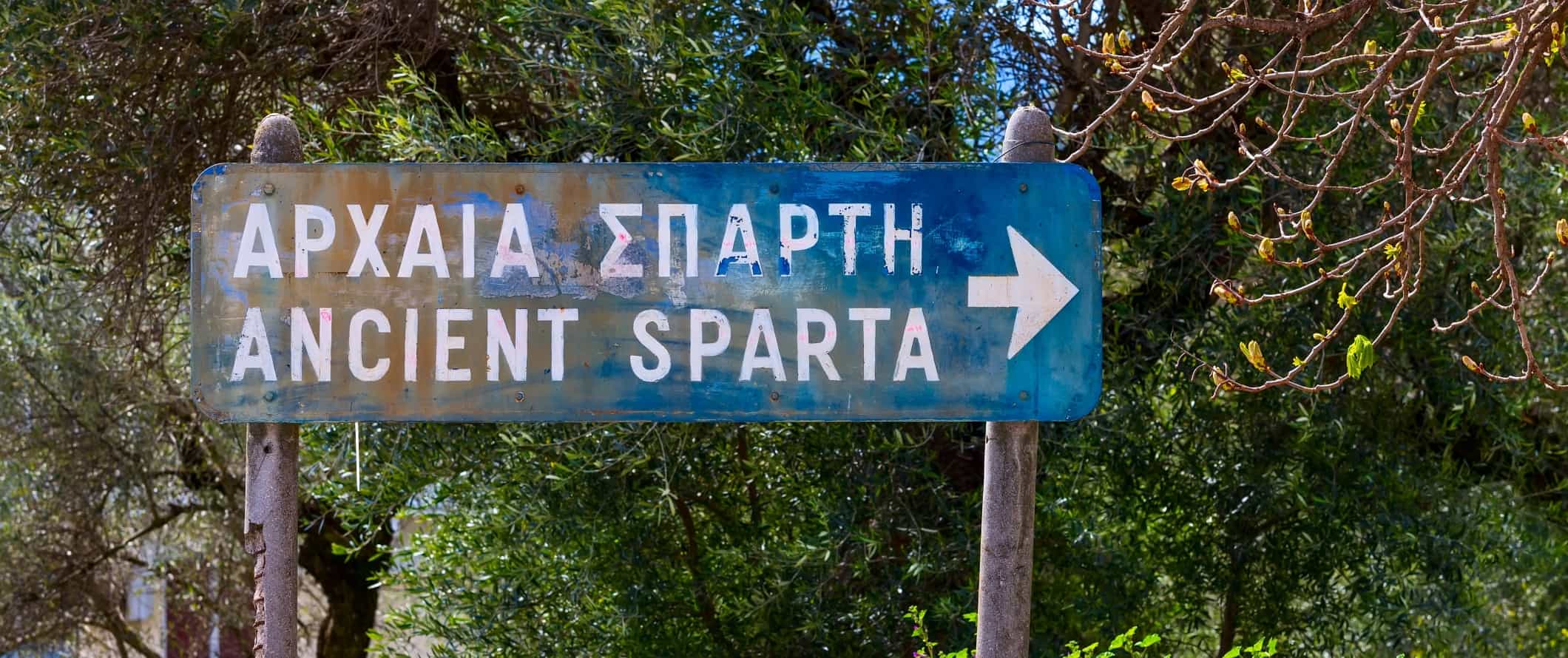 Blue road sign pointing to Ancient Sparta in Greece.