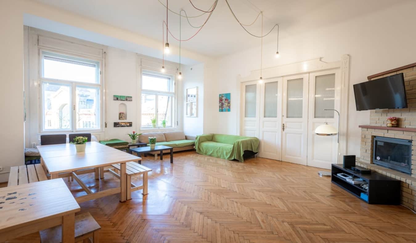 brightly lit common room with couches and tables at Spicy Hostel in Budapest