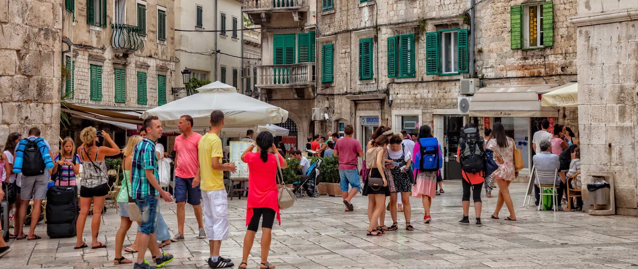 People walking down a narrow old street in Split, Croatia